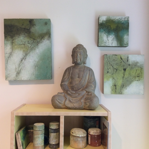 buddha and paintings in the artist's studio